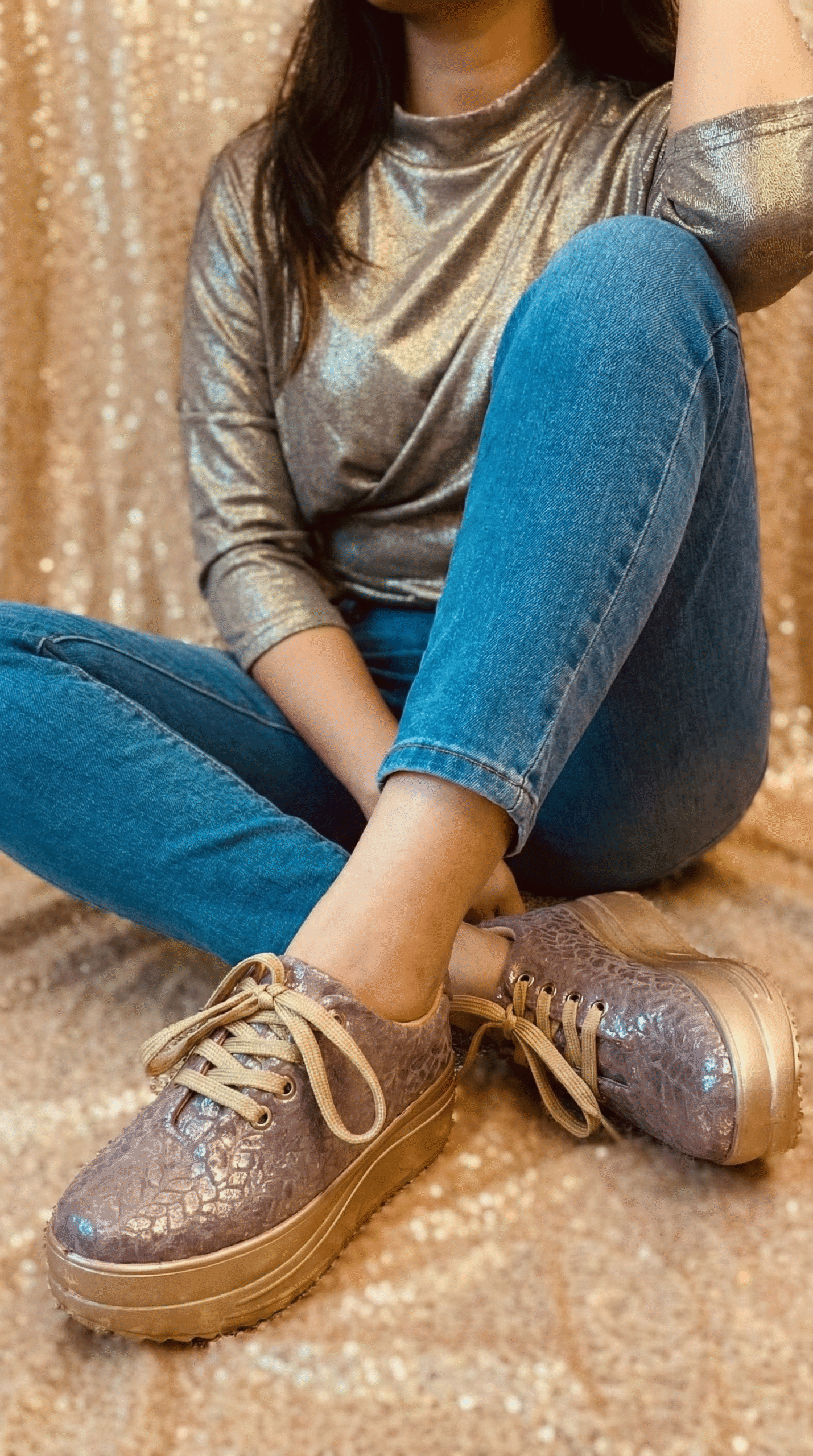 Firefly_Gemini Flash_Create an image in which a model is wearing nice golden grey top the jeans with sneak 173072